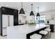 Modern kitchen features black and white cabinetry, a large center island with seating, and pendant lighting at 6759 E Aire Libre Ln, Scottsdale, AZ 85254