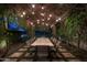 Outdoor patio dining area with stone table, string lights, and lush greenery at 7305 E Royal Palm Rd, Scottsdale, AZ 85258