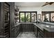 Dark wood wet bar with ample storage, a wine cooler, and herringbone tile flooring at 7305 E Royal Palm Rd, Scottsdale, AZ 85258