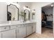 Bathroom featuring a double sink vanity, designer mirrors, and an open door to the walk-in closet at 7709 S 72Nd Dl, Laveen, AZ 85339