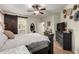 Well-lit primary bedroom with a ceiling fan, wood floors, decorative baskets and ensuite bathroom at 7709 S 72Nd Dl, Laveen, AZ 85339