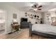 Bright primary bedroom featuring wood floors, a ceiling fan, TV, and an ensuite bathroom at 7709 S 72Nd Dl, Laveen, AZ 85339