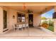 Relaxing covered patio featuring a swing, ceiling fan, dining table set, and access to the backyard at 7709 S 72Nd Dl, Laveen, AZ 85339