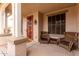 Inviting front porch with cozy seating and a decorative front door at 7709 S 72Nd Dl, Laveen, AZ 85339