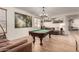 Relax in this game room with the pool table, custom decor and seamless flow to other spaces in the home at 7709 S 72Nd Dl, Laveen, AZ 85339
