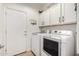 Laundry room with white appliances and storage cabinets above the washer and dryer at 7709 S 72Nd Dl, Laveen, AZ 85339