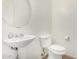 Small bathroom with pedestal sink, toilet, and a large round mirror at 832 E Stottler Dr, Gilbert, AZ 85296