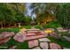 Backyard with stone steps and walkways leading to the expansive green lawn at 5747 E Mockingbird Ln, Paradise Valley, AZ 85253