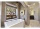 This luxurious bathroom features a soaking tub and a view to the outdoors through a casement window at 5747 E Mockingbird Ln, Paradise Valley, AZ 85253