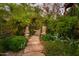 Stone pathway through lush greenery, featuring lion statues at the gate at 5747 E Mockingbird Ln, Paradise Valley, AZ 85253