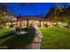 Charming home exterior with well-manicured lawn, stone pathway and cozy lighting at 5747 E Mockingbird Ln, Paradise Valley, AZ 85253