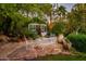 Lush garden space featuring a greenhouse, stone pavers, potted plants, and seating at 5747 E Mockingbird Ln, Paradise Valley, AZ 85253