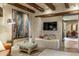 Relax in this living room, featuring exposed wood beams, unique decor, and plenty of natural light at 5747 E Mockingbird Ln, Paradise Valley, AZ 85253