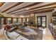 Bright living room with a fireplace, neutral walls, wood-beamed ceiling, and a large window with backyard views at 5747 E Mockingbird Ln, Paradise Valley, AZ 85253