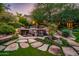 Tranquil backyard pool with rock waterfall feature, lush landscaping, and stone walkway to main house at 5747 E Mockingbird Ln, Paradise Valley, AZ 85253
