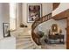 Elegant curved staircase with custom wood banister, complemented by unique artwork and decor at 5747 E Mockingbird Ln, Paradise Valley, AZ 85253
