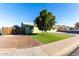 Green house with artificial turf, tree, and a paved driveway at 10395 N 73Rd Dr, Peoria, AZ 85345