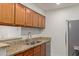 Kitchen with double sink, granite counters, and wood cabinets at 10610 S 48Th St # 2089, Phoenix, AZ 85044