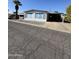 Single-wide mobile home with carport and mature palm tree at 120 N Val Vista Dr # 38, Mesa, AZ 85213