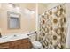 Clean bathroom with a floral shower curtain and wood vanity at 15107 W Las Brizas Ln, Sun City West, AZ 85375