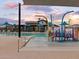 Resort-style pool with a splash pad and shade umbrellas at 15994 W Cottontail Ln, Surprise, AZ 85387