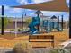 Scenic view of the community playground with swings and a covered seating area at 16030 W Desert Hollow Dr, Surprise, AZ 85387