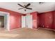 Red-walled bedroom with ceiling fan and attached bath at 18741 N Vemto St, Maricopa, AZ 85138