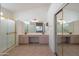 Bathroom with double sinks, shower, and mirrored closet at 19810 N 90Th Ln, Peoria, AZ 85382
