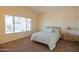 Bedroom with carpeted floor, ceiling fan, and a window with backyard view at 19810 N 90Th Ln, Peoria, AZ 85382