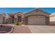 Tan house with stone facade and a two-car garage at 19810 N 90Th Ln, Peoria, AZ 85382