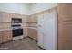 Kitchen boasts white appliances, ample cabinetry, and a large refrigerator at 19810 N 90Th Ln, Peoria, AZ 85382