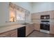 Kitchen with wood cabinets, white appliances, and a window overlooking the backyard at 19810 N 90Th Ln, Peoria, AZ 85382