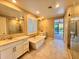 Elegant bathroom with soaking tub, double vanity, and walk-in shower at 2074 N 139 Dr, Goodyear, AZ 85395