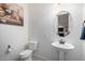 Powder room with pedestal sink and oval mirror at 3222 S 186Th Ln, Goodyear, AZ 85338