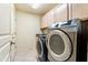 Bright laundry room with washer, dryer, and cabinets at 3830 E Carter Dr, Phoenix, AZ 85042