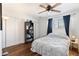 Cozy bedroom with a queen bed, built-in shelving, and hardwood floors at 4641 W Palo Verde Ave, Glendale, AZ 85302
