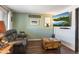Living room with a large TV, comfortable seating, and wood-look floors at 4641 W Palo Verde Ave, Glendale, AZ 85302