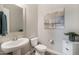 Clean bathroom with pedestal sink, toilet and decorative mirror at 5508 N 190Th Dr, Litchfield Park, AZ 85340