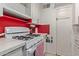 White kitchen cabinets, red backsplash, and a gas stove at 633 W 1St St, Mesa, AZ 85201