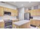 Kitchen with island, wood cabinets, and stainless steel appliances at 7278 W Via Montoya Dr, Glendale, AZ 85310