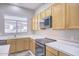 Kitchen with wood cabinets, stainless steel appliances, and a large window at 7278 W Via Montoya Dr, Glendale, AZ 85310