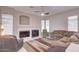 Living room with fireplace, neutral colored furniture, and large windows at 7278 W Via Montoya Dr, Glendale, AZ 85310
