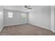 Bright bedroom with neutral carpet, ceiling fan, and view of the outside through dual windows at 9839 E Theia Dr, Mesa, AZ 85212