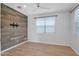 Bedroom features wood accent wall, ceiling fan, modern window treatments, and light wood flooring at 9839 E Theia Dr, Mesa, AZ 85212