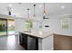 Bright open floorplan kitchen features stainless steel appliances, island, and sliding door to pool at 9839 E Theia Dr, Mesa, AZ 85212