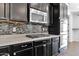 Close-up of stainless steel microwave, oven, gas cooktop, dark cabinets, and tiled backsplash at 9839 E Theia Dr, Mesa, AZ 85212