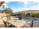 Enjoy this kidney shaped pool with patio furniture and fire pit at 9839 E Theia Dr, Mesa, AZ 85212