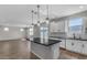 Modern kitchen with white cabinets, island, and stainless steel appliances at 10993 W Pierce St, Avondale, AZ 85323