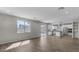 Open living room with wood-look tile floors and views to kitchen at 10993 W Pierce St, Avondale, AZ 85323