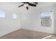 Well-lit bedroom with neutral carpet and two windows at 11640 W Duran Ave, Youngtown, AZ 85363